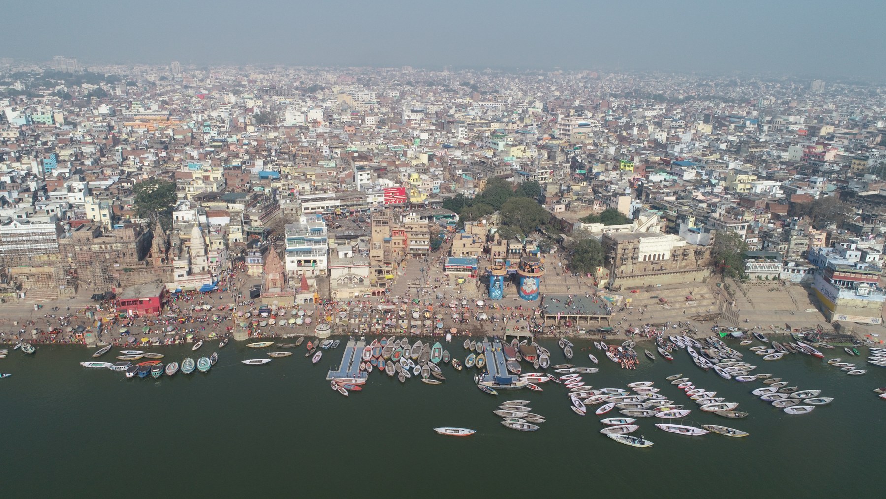 Aerial view of Varanasi's riverfront ghats along the Ganges, lined with boats